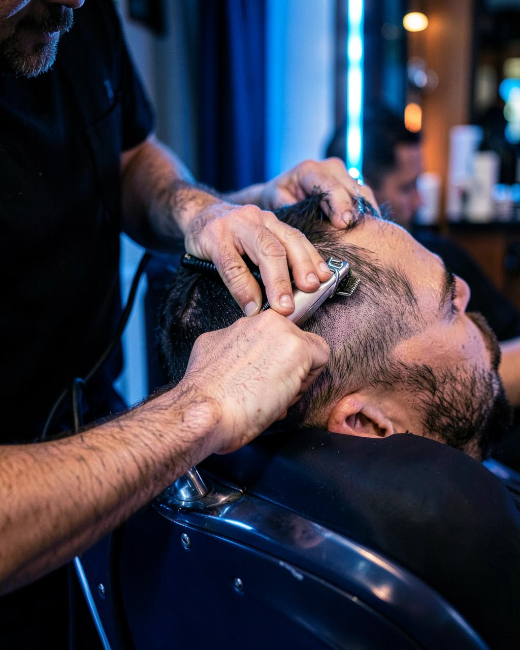 Professional barber shaping a fade with clippers